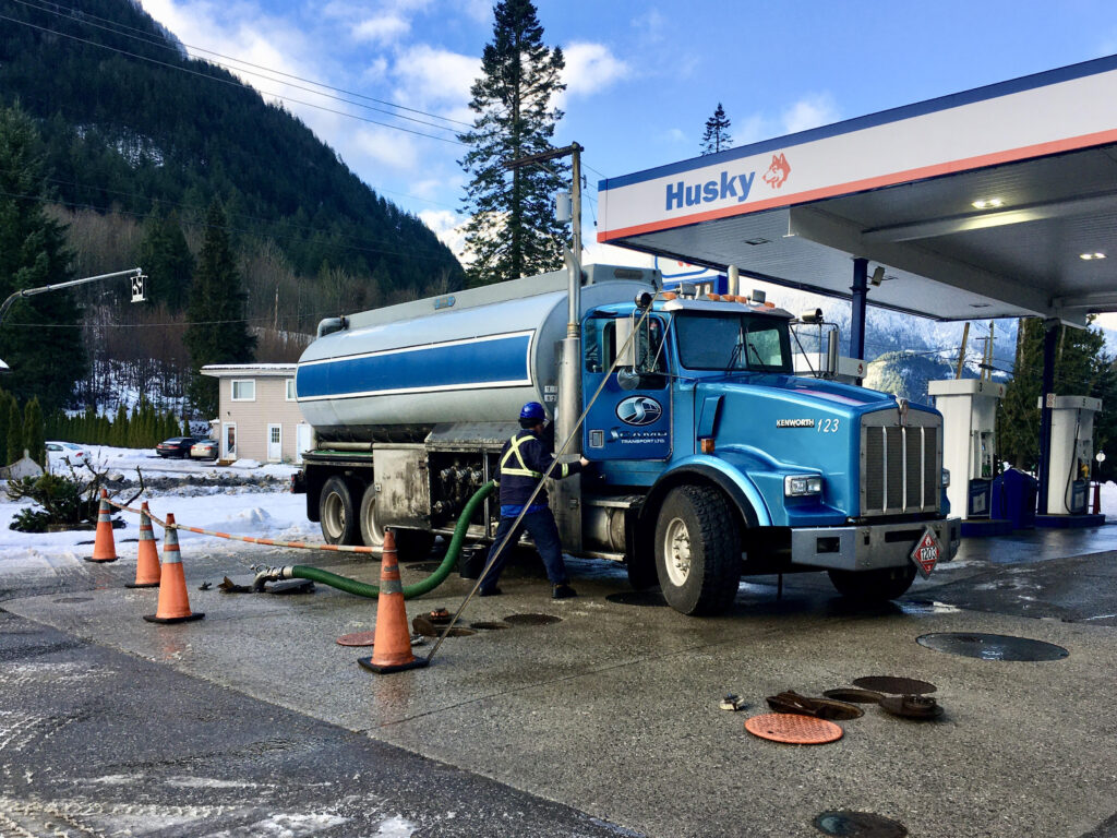 fuel truck refills holding tanks at a gas station in british columbia