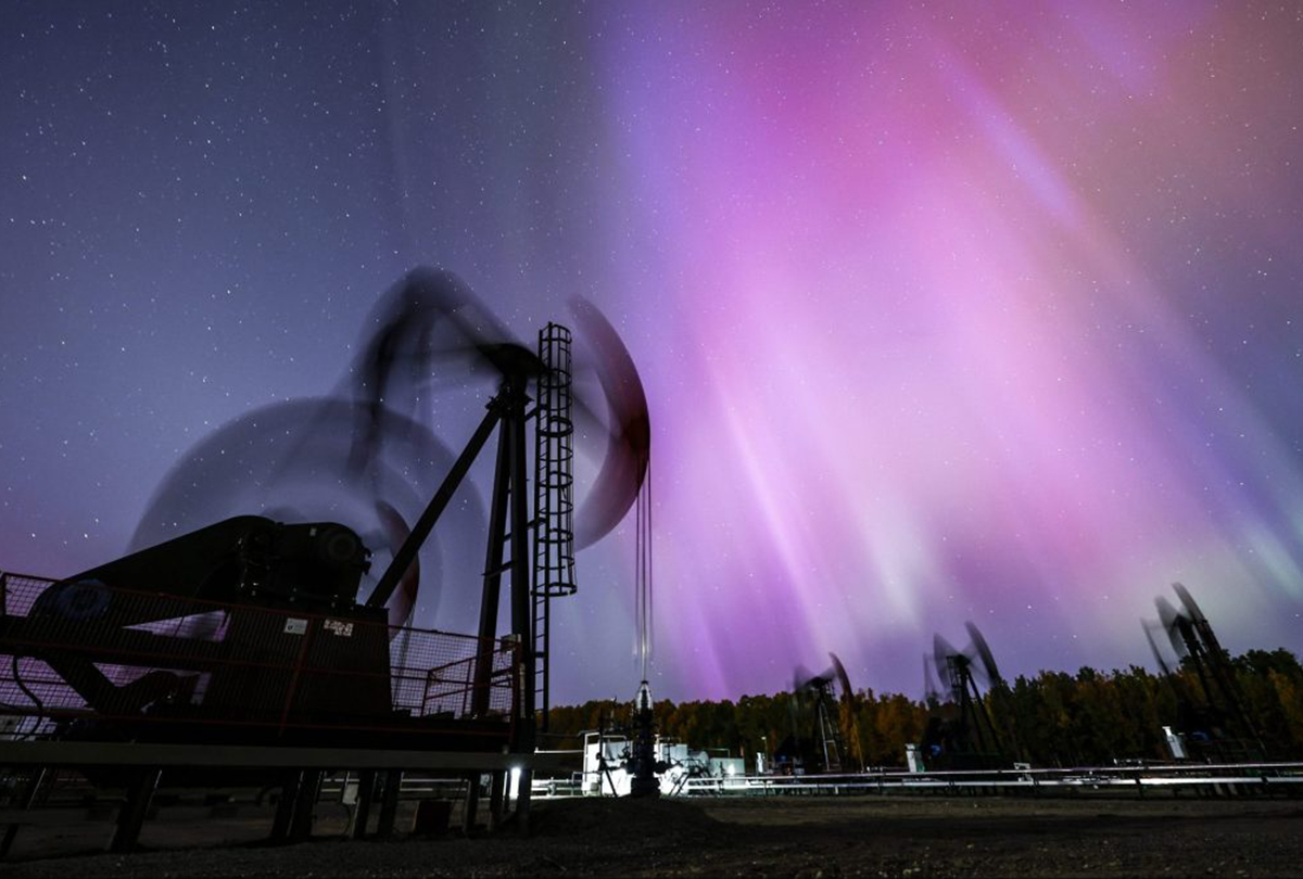 the northern lights, aurora borealis, make an appearance over pumpjacks near cremona 1200x810